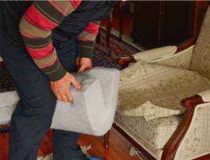 Person stuffing foam into a chair slipcover